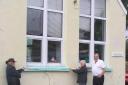 Yr Hen Ysgol management committee members Pete & Sheila Duffill help High Sheriff volunteer Brian Murray to measure their community hall frontage.