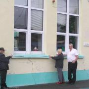 Yr Hen Ysgol management committee members Pete & Sheila Duffill help High Sheriff volunteer Brian Murray to measure their community hall frontage.