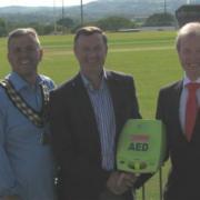 Pilgrimage presentation: BHF Ambassador Huw Roberts is pictured handing  the defibrillator to Dr Byron McNeil. With them are John Davies, chairman of Whitland Cricket Club; Whitland mayor, Neil Jenkins and Alun Ifans secretary of Cymdeithas Waldo.