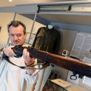 Tenby Museum's Mark Lewis gets his sights on a World War One rifle which is on display in the latest exhibition. PICTURE: Gareth Davies Photography