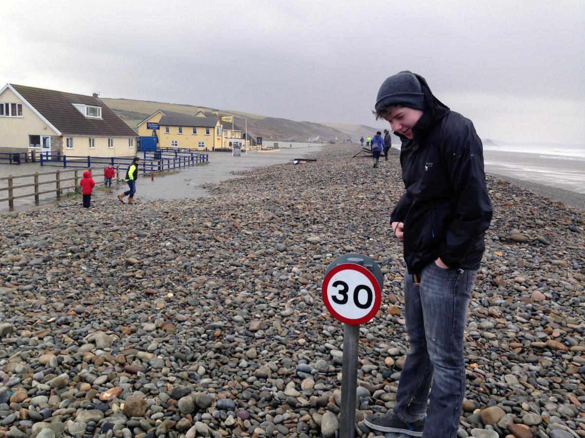 Newgale: Joshua McManamon stands next to a 30mph sign, where the road would normally be. Picture taken by Christopher McManamon