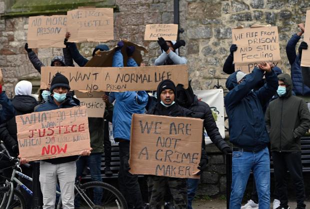 Western Telegraph: The asylum seekers aired their grievances vocally and on their banners during their second protest since last night. Picture: Gareth Davies Photography