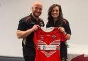 Head coach Thomas Brindle presents Emily Hughes with her Wales Rugby League shirt.