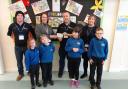 Children and staff from the LRC at Ysgol Glannau Gwaun receive a £1,000 cheque from Fishguard and District Round Table. Picture:  Western Telegraph