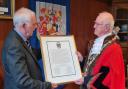 Pastor Rob James, Mayor’s Chaplain, hands the scroll to the Mayor of Pembroke, Cllr Aden Brinn .