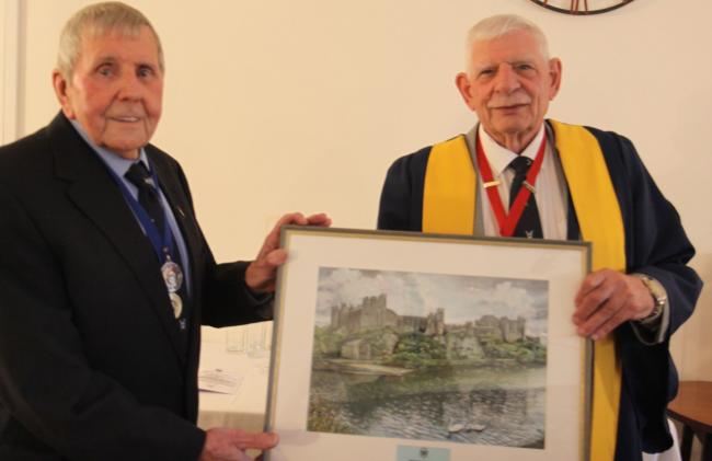 Cllr Dennis Evans presents Roy Folland with a specially commissioned painting of Pembroke Castle in recognition of his service of thirty years