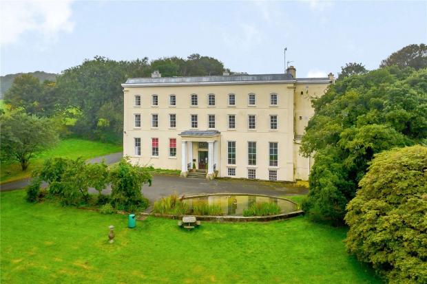 Western Telegraph: A portico'd entrance and a pond greet visitors to the Grade II Listed mansion. Picture: Savills, Cardiff