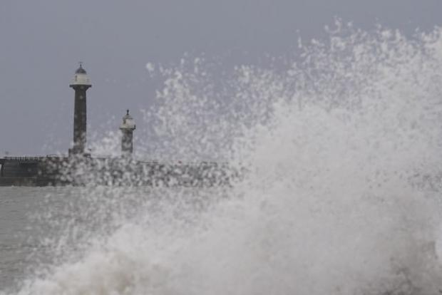Western Telegraph: Big waves against the sea wall in Whitby, Yorkshire. Photo via PA/Danny Lawson.