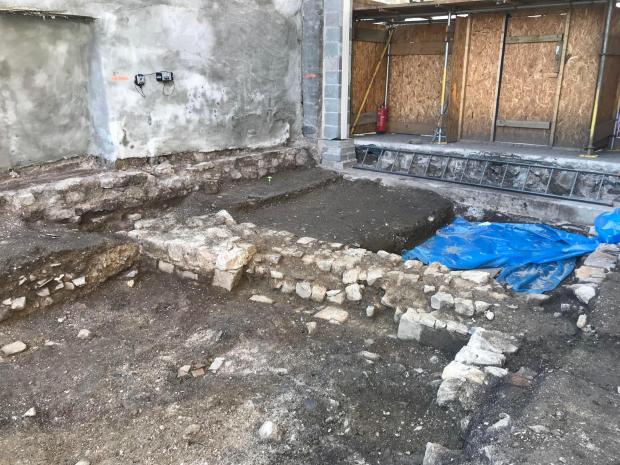 Western Telegraph: A medieval wall. Beneath the blue sheet was where some of the bodies were found