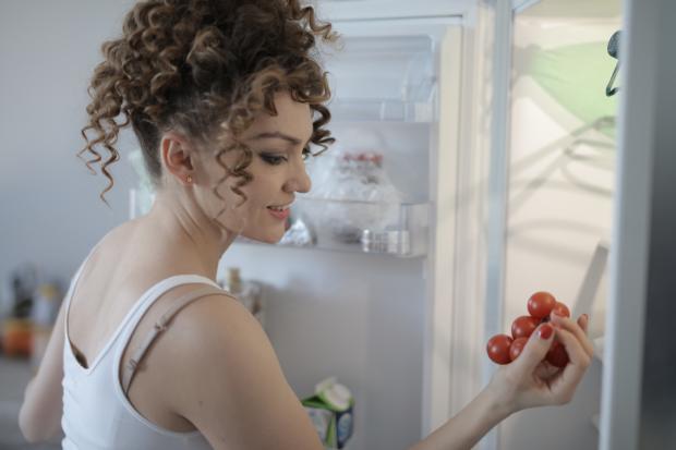 Western Telegraph: A woman putting tomatoes in her fridge. Credit: Canva