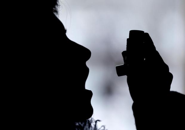 Western Telegraph: Silhouette of a person using an inhaler. Credit: Canva