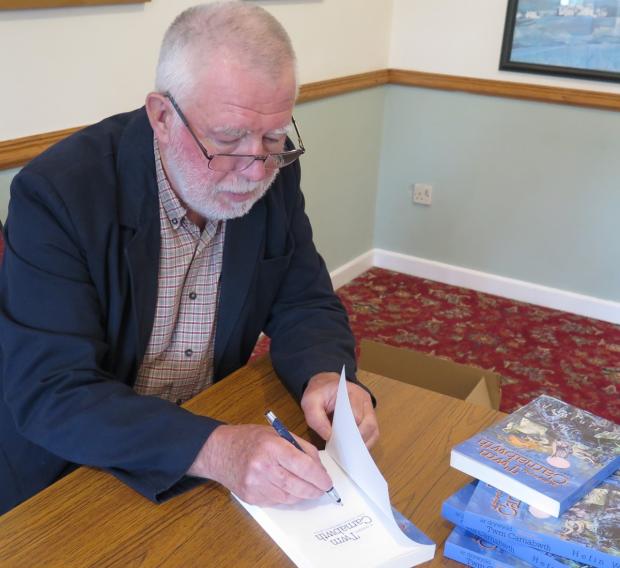 Western Telegraph: Author, Hefin Wyn, signing copies of his recent publication at the Caffi Beca book launch in Efail-wen