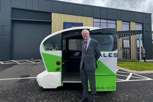 First Minister Mark Drakeford next to an autonomous vehicle. (Welsh Government)