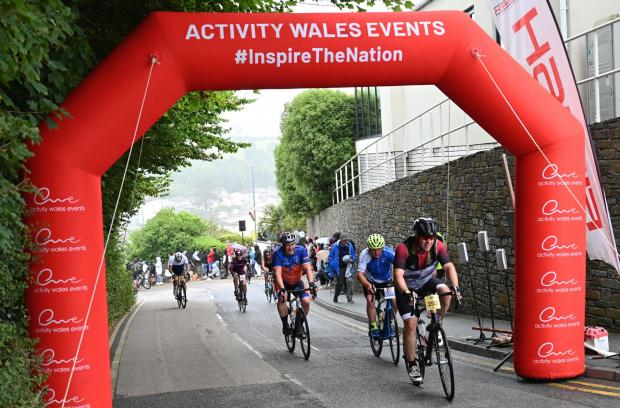 Western Telegraph: The worst of the hill is over as riders make their way under the Activity Wales Events arch. Picture: Gareth Davies Photography