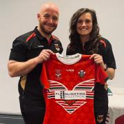 Head coach Thomas Brindle presents Emily Hughes with her Wales Rugby League shirt.