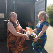 Gwenno Dafydd, right, hands over the box of food to the food pod's Lesley Matthews.