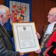 Pastor Rob James, Mayor’s Chaplain, hands the scroll to the Mayor of Pembroke, Cllr Aden Brinn .