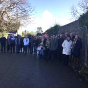 Campaigners say that demolishing a section of the listed 350-year-old wall would 'desecrate' the village.
