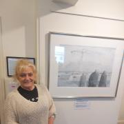 Theatr Gwaun trustee Blanche Giacci is pictured alongside one of the works on display.
